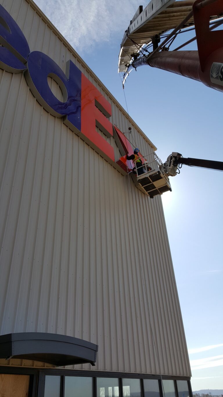 MRC Signs bucket truck servicing a building sign